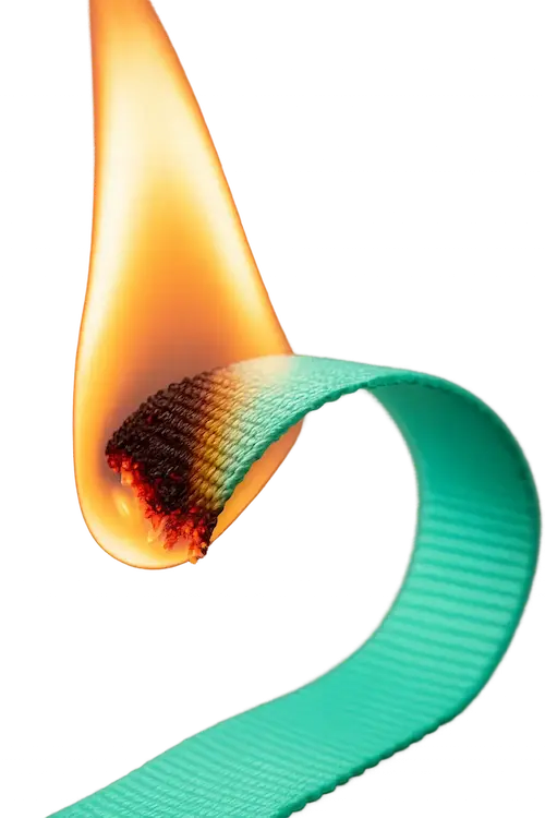 a burn test on a piece of webbing over a flame.