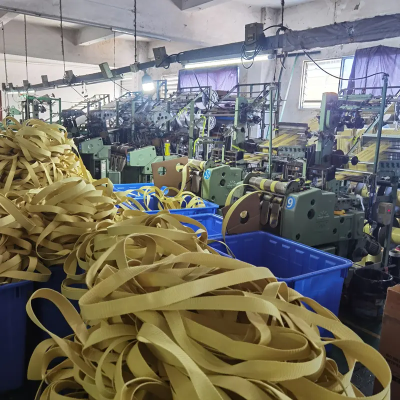 Rolls of yellow KEVLAR aramid webbing are producing, known for its flame retardant and bulletproof properties.
