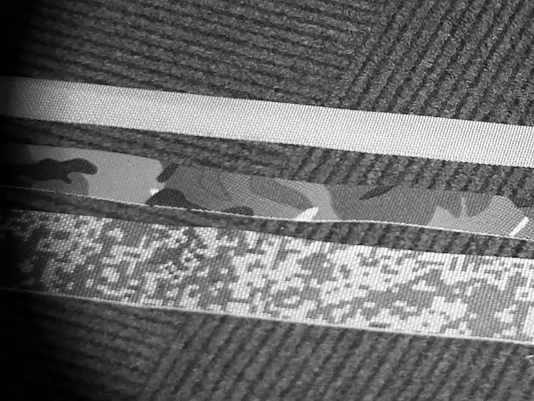 A close-up of IRR military webbing attached to a MOLLE tactical vest.