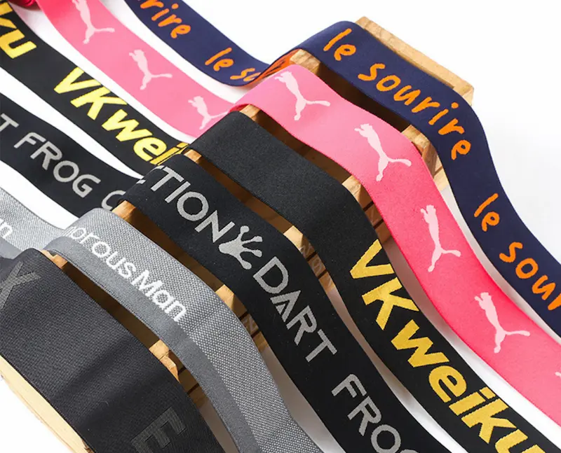A vibrant collection of different types of elastic webbing, including woven, knitted, and jacquard elastic bands.