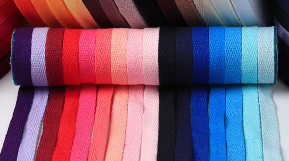 A collection of natural-colored cotton webbing rolls, highlighting their soft texture.