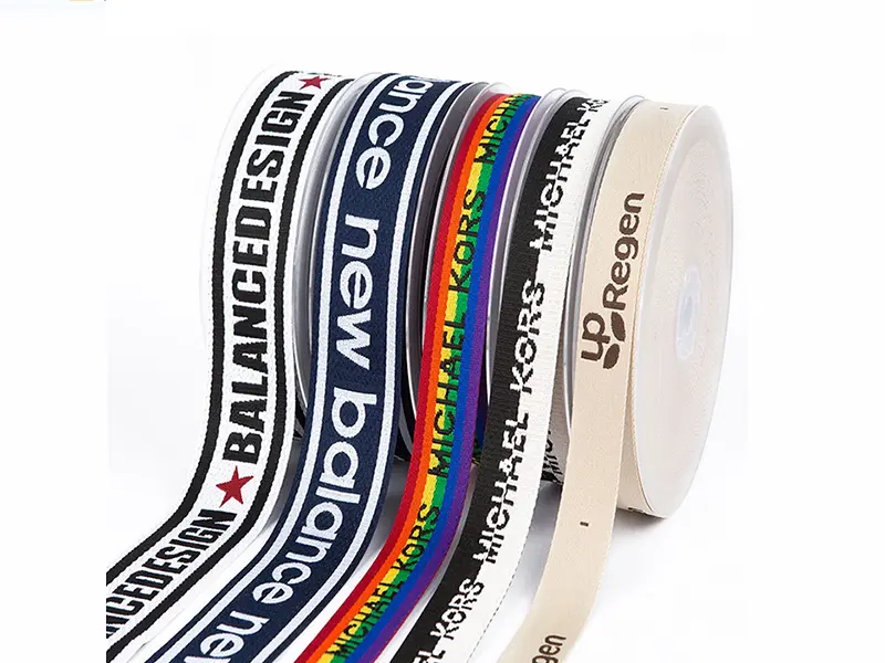 Close-up of a custom multi-colored jacquard webbing, showing its intricate woven logo pattern.