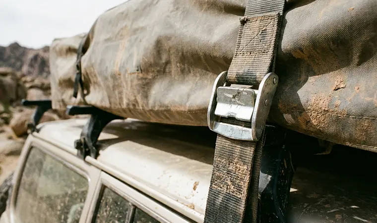 Close up of a durable polyester strap securing a rooftop tent travel cover.